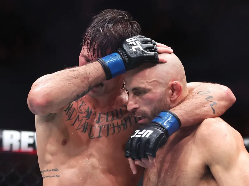 Alexander Volkanovski embraced by Diego Lopes in the Octagon after their UFC 325 title rematch in Sydney